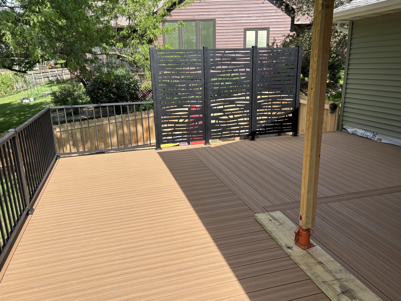 Two-tone composite deck with decorative metal privacy screens in Iowa City Iowa