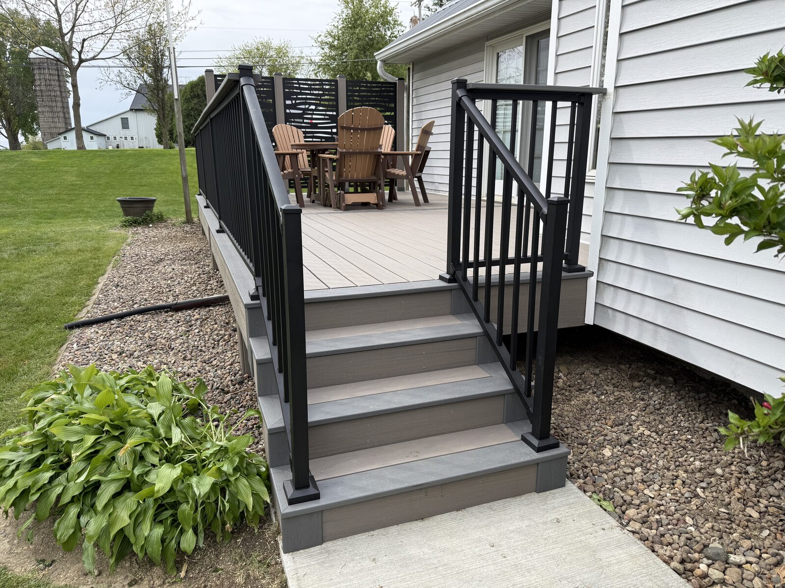 Deck stairs with black aluminum railing and landscaping, T&T Home Improvement Iowa City