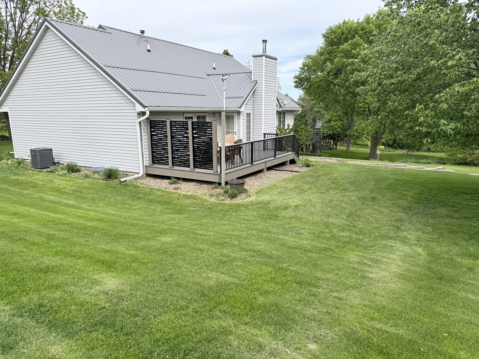 Full yard view of composite deck with privacy screens in Iowa City Iowa